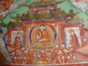 チベット僧院内での学びの様子を描いた絵画。中央に座す師の前で、弟子たちが手を打ち鳴らしながらながら問答している。